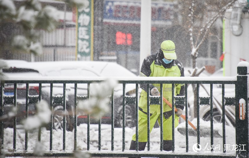 環(huán)衛(wèi)工人正在清理道路積雪。人民網(wǎng)記者 蘇靖剛攝